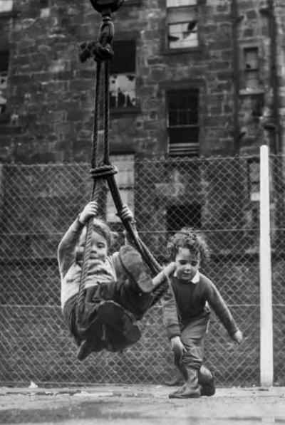 Playing on a swing in front of a slum